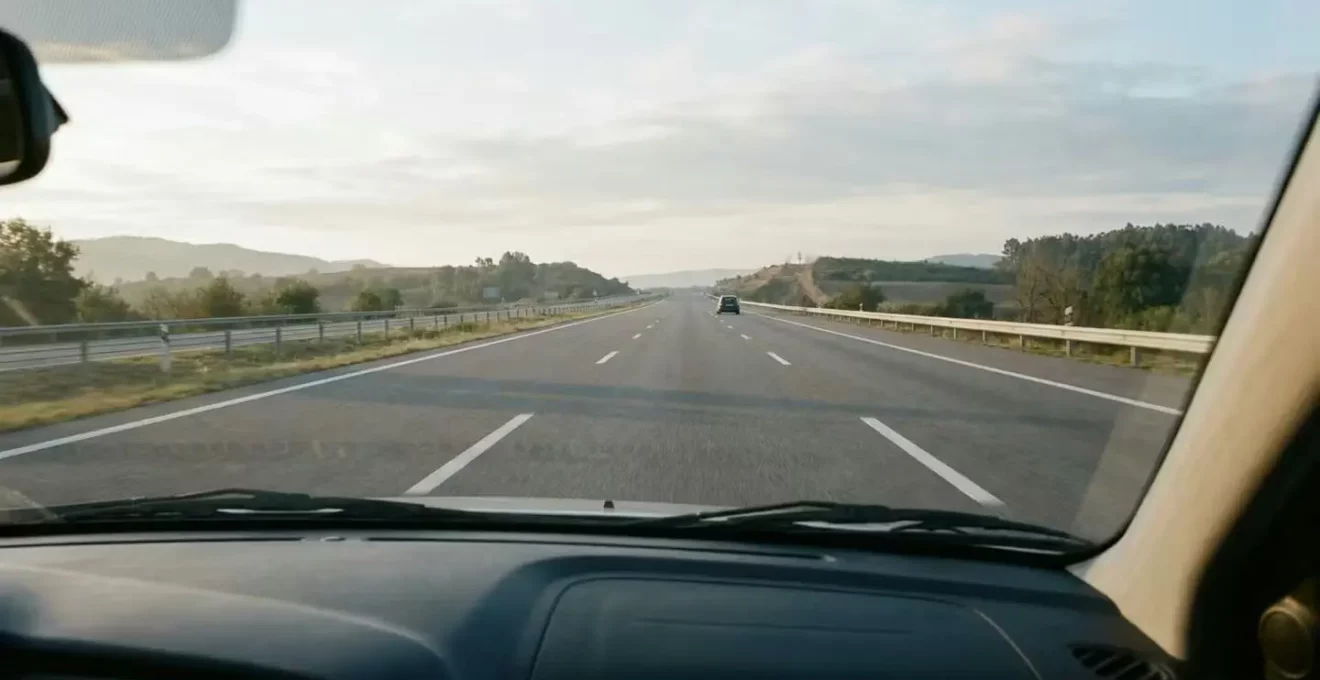 Vue intérieure d'une voiture maintenant une distance de sécurité importante avec un véhicule agressif devant