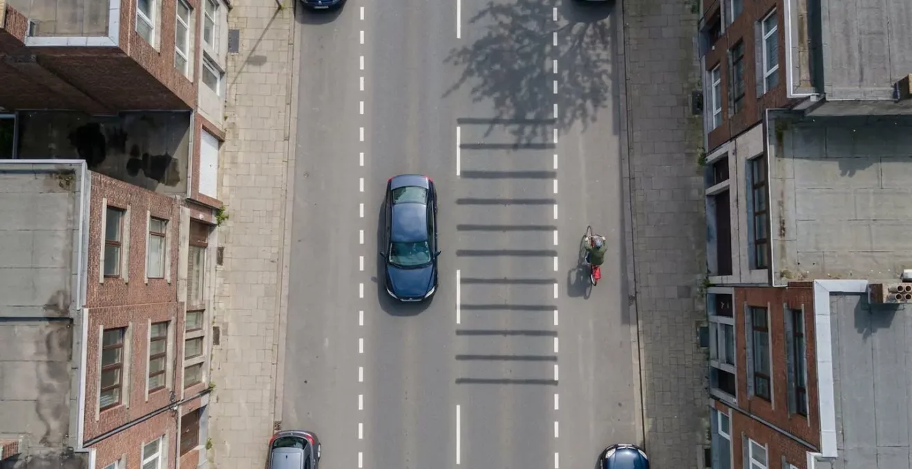 Vue aérienne montrant la distance de sécurité lors du dépassement d'un cycliste en zone 30